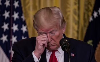 trump rubbing eye podium